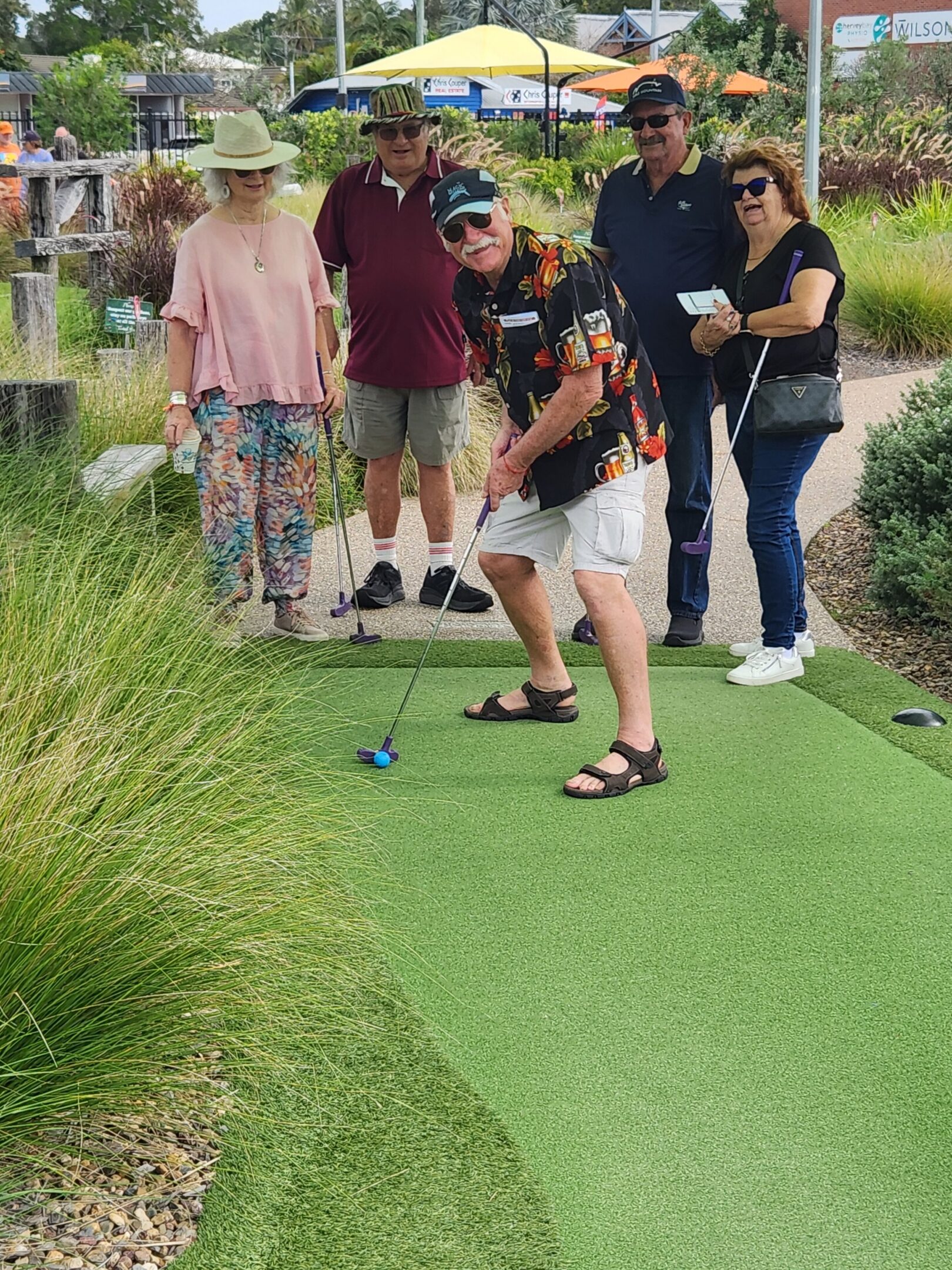 Group of people playing mini golf outdoors