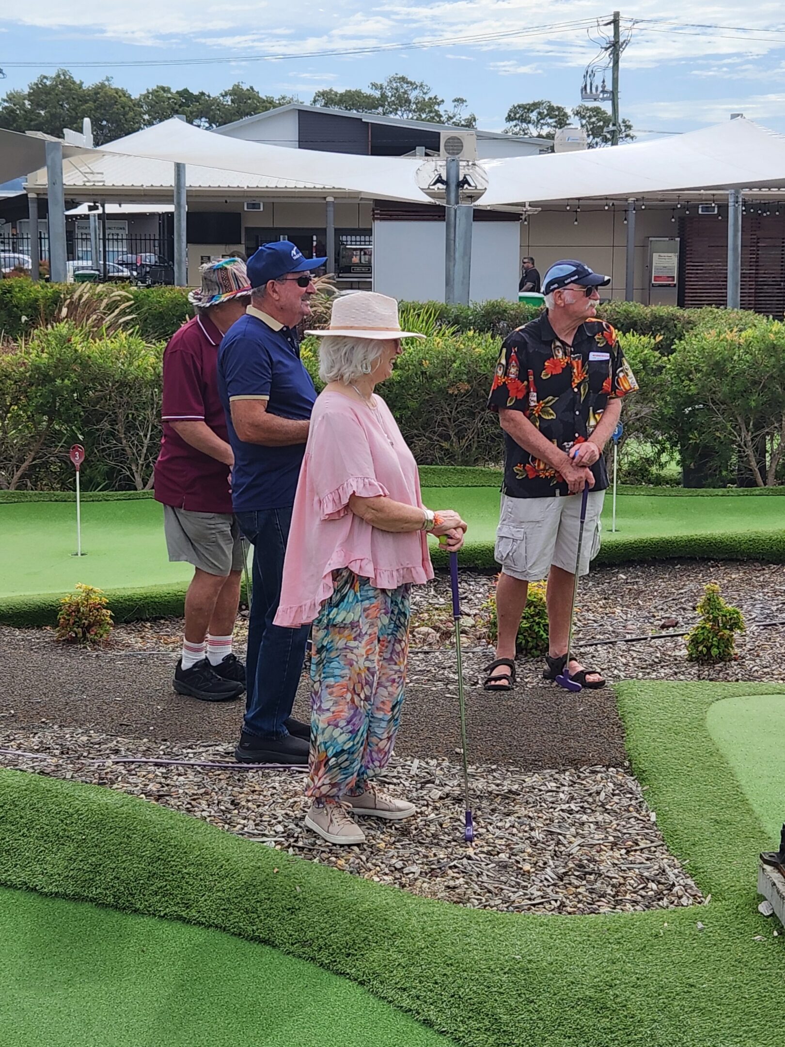 Group of seniors playing mini golf outdoors