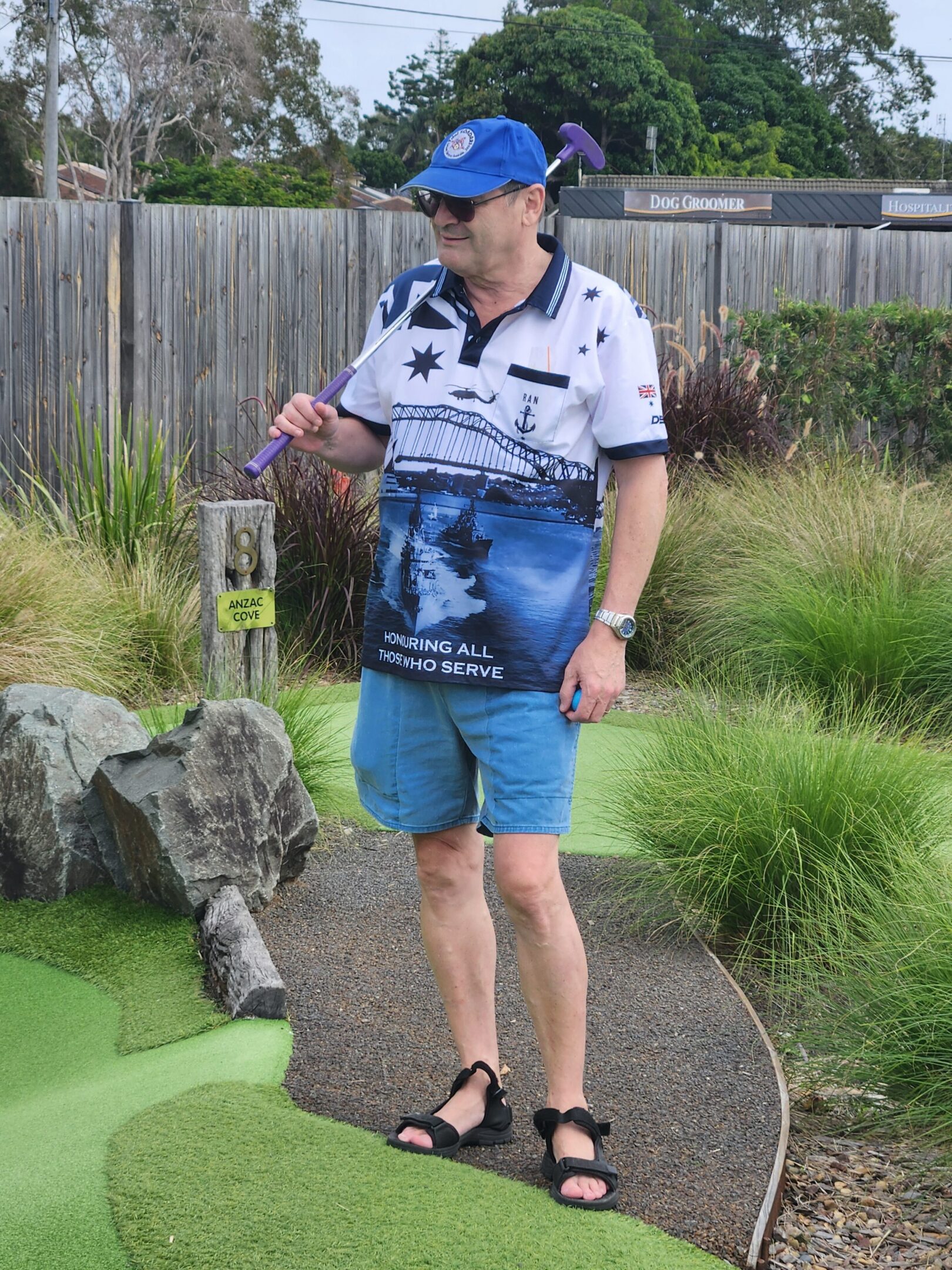 Man playing mini golf holding purple putter